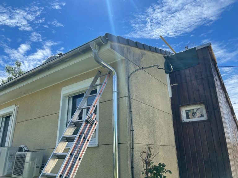Façade enduite d’une maison avec échelle en place et descente de gouttière neuve
