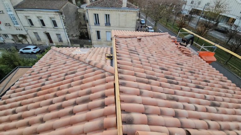 Toiture en tuiles de terre cuite en bon état sur une maison de ville en Gironde